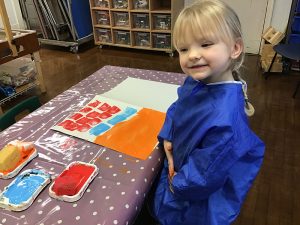 Girl painting in Early learning and childcare class